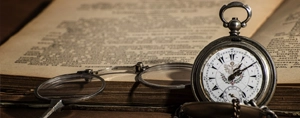 Biblia abierta del Antiguo Testamento con un reloj de bolsillo y gafas de lectura, simbolizando que la Ley de Dios es eterna.